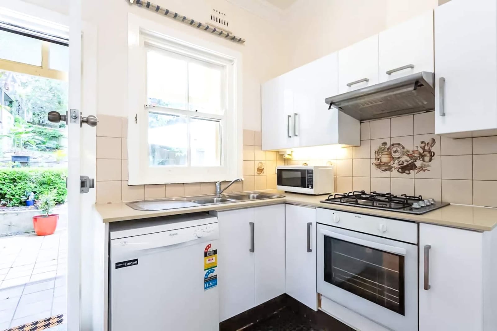 Downstairs kitchen, white cabinets and a window